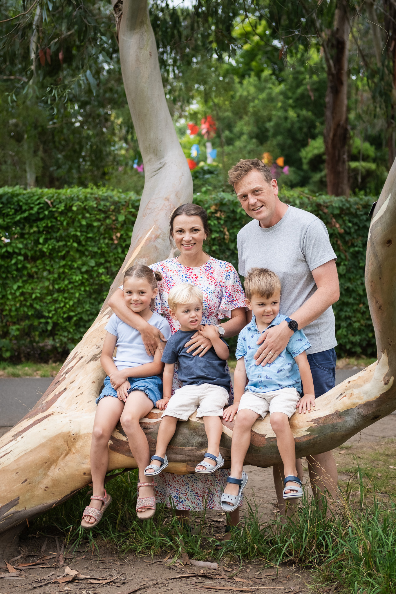 Family of five by a tree, smiling and enjoying family photoshoot