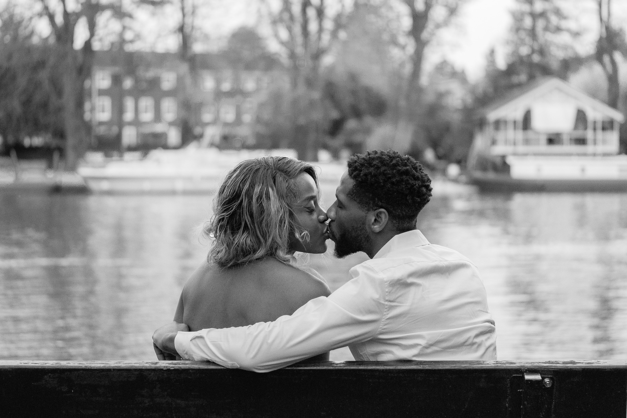 Love couple, sitting on a bench on by the river and kissing