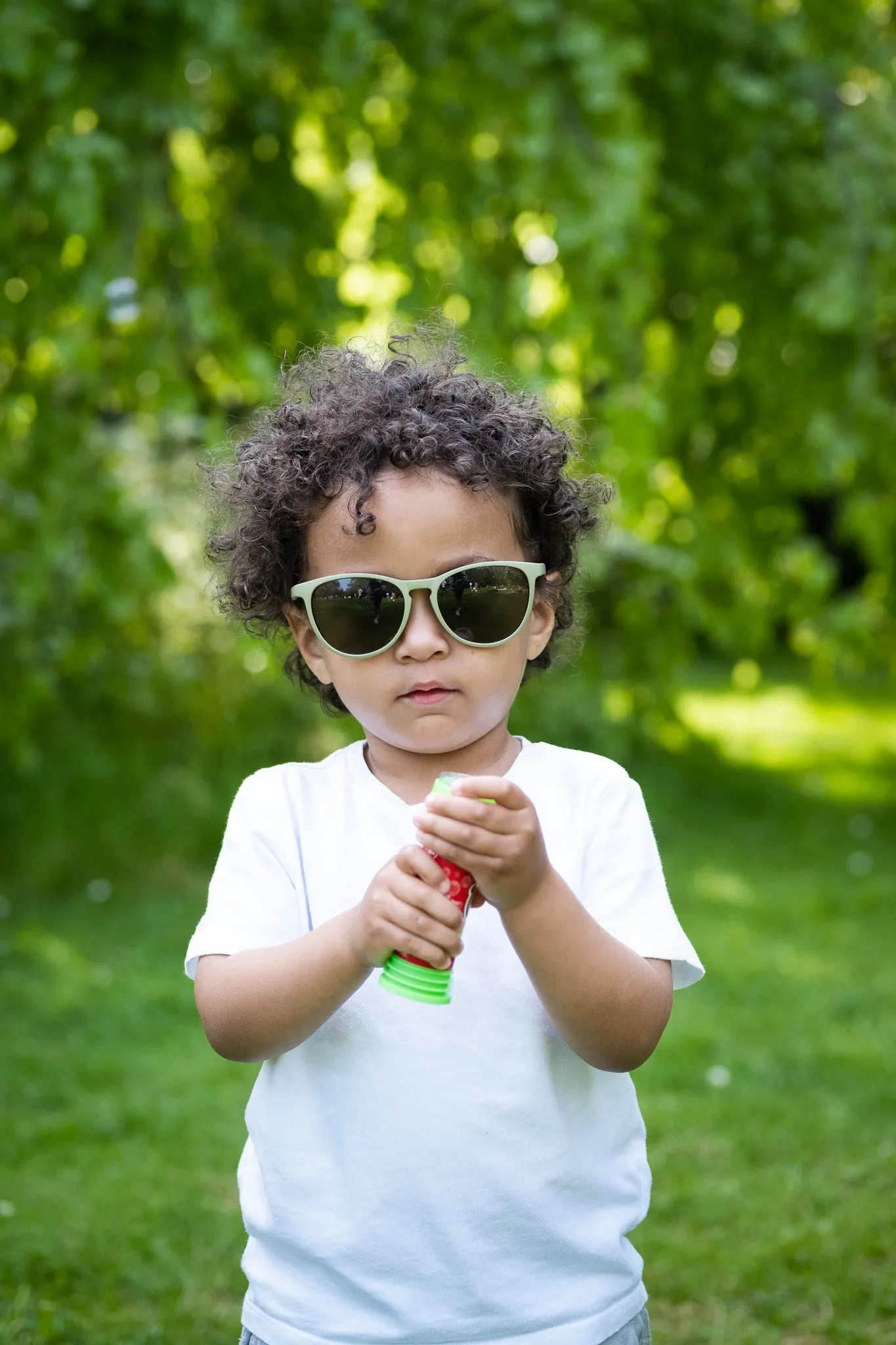 Little boy in a park for a family photoshoot with his family