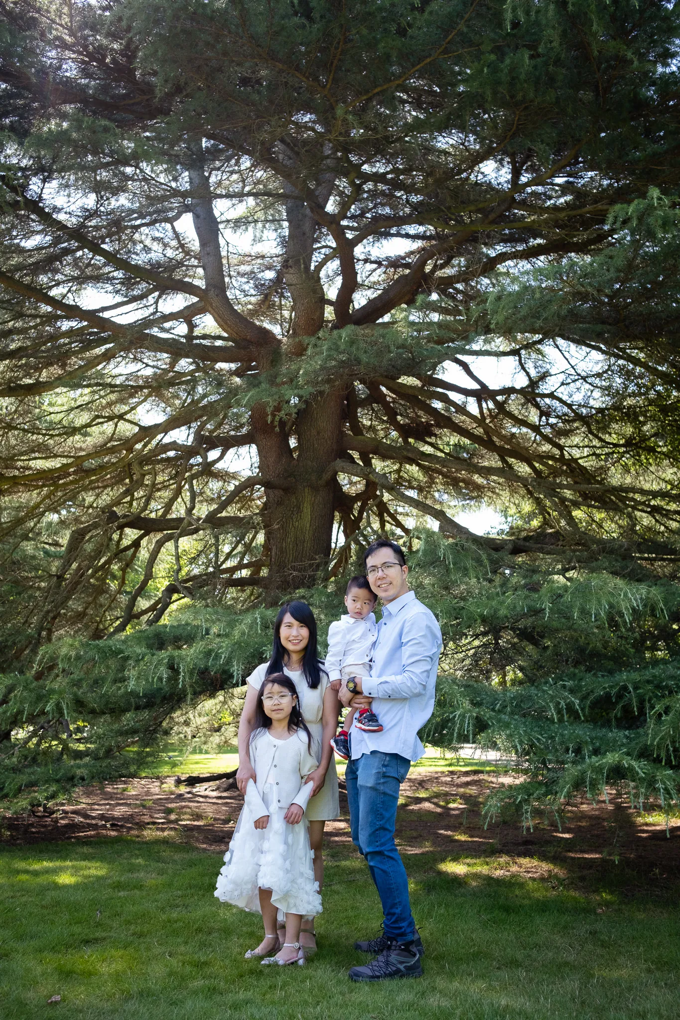 Family of four at the park, enjoying warm weather, while having an outdoor family photoshoot