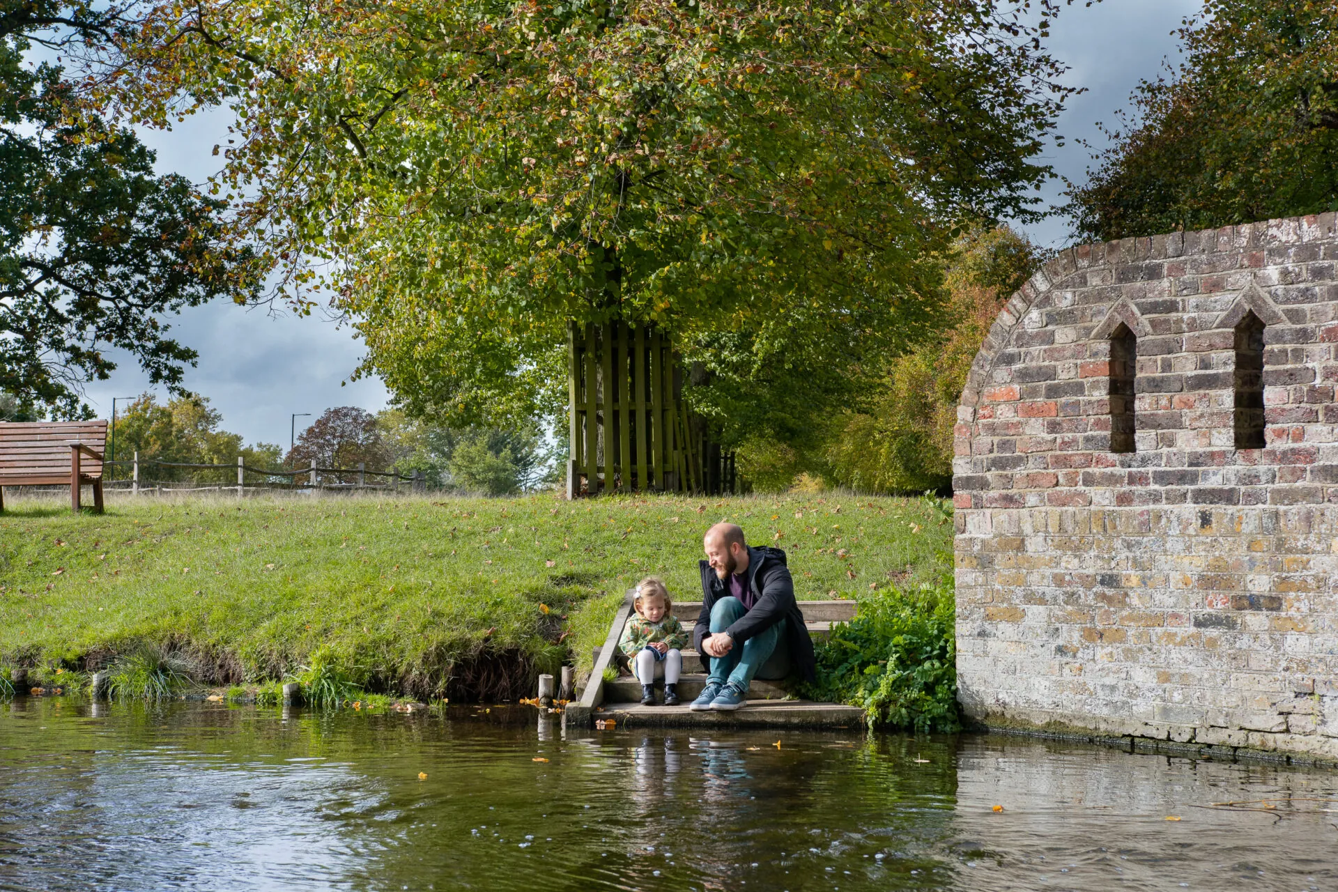 Father and daughter, sitting close to river, outdoor family autumn photography from Mellsnap