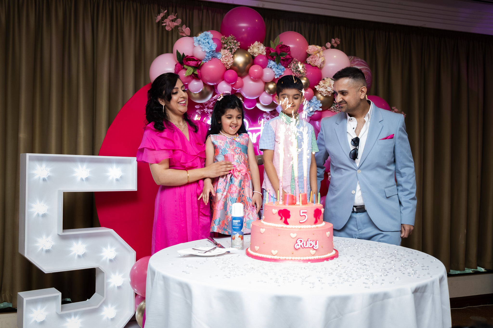 5th year Birthday party, family of four is celebrating with a cake