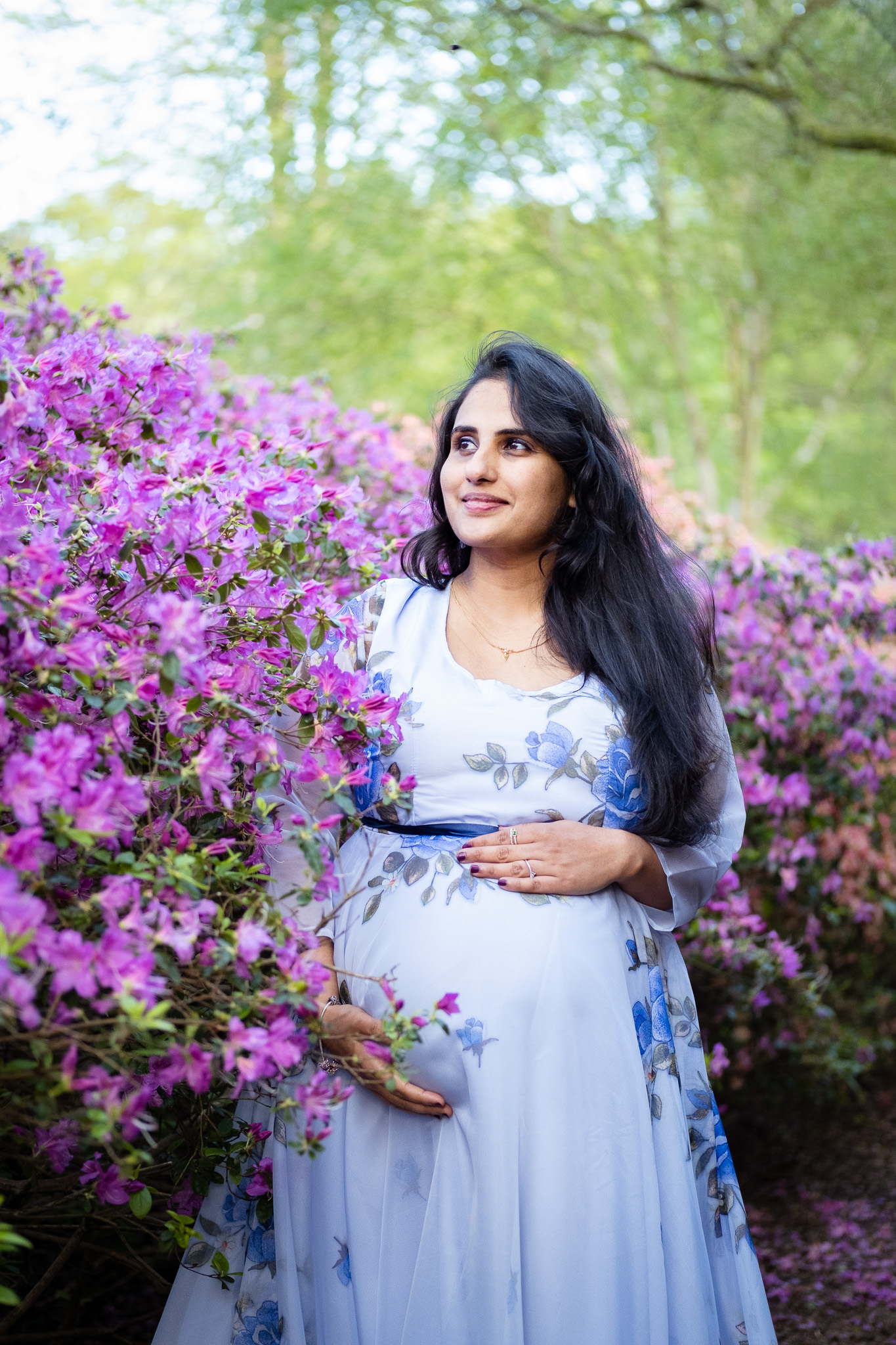 Pregnant woman surrounded by nature and purple flowers