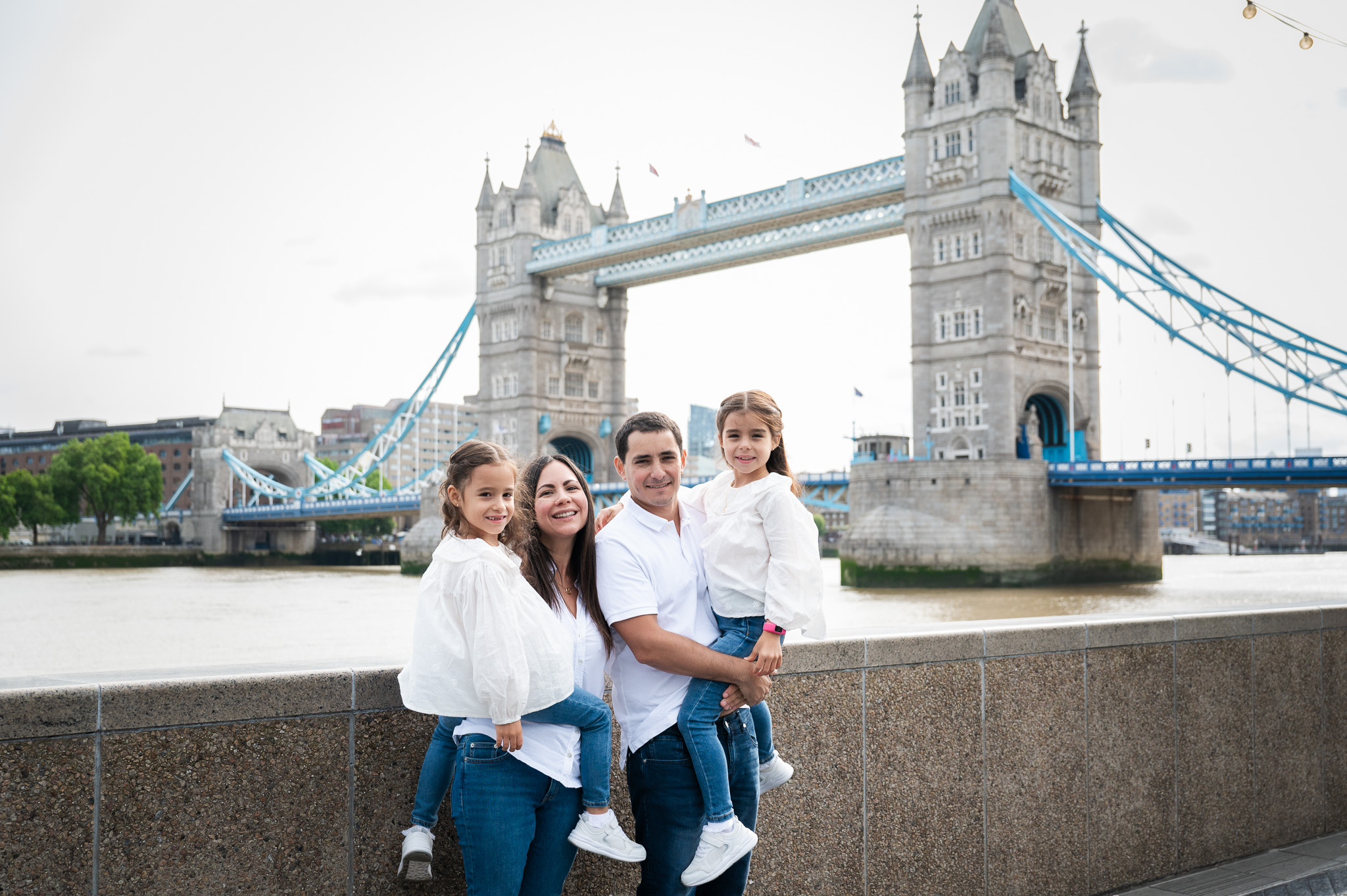 Family of four in front of London bridge