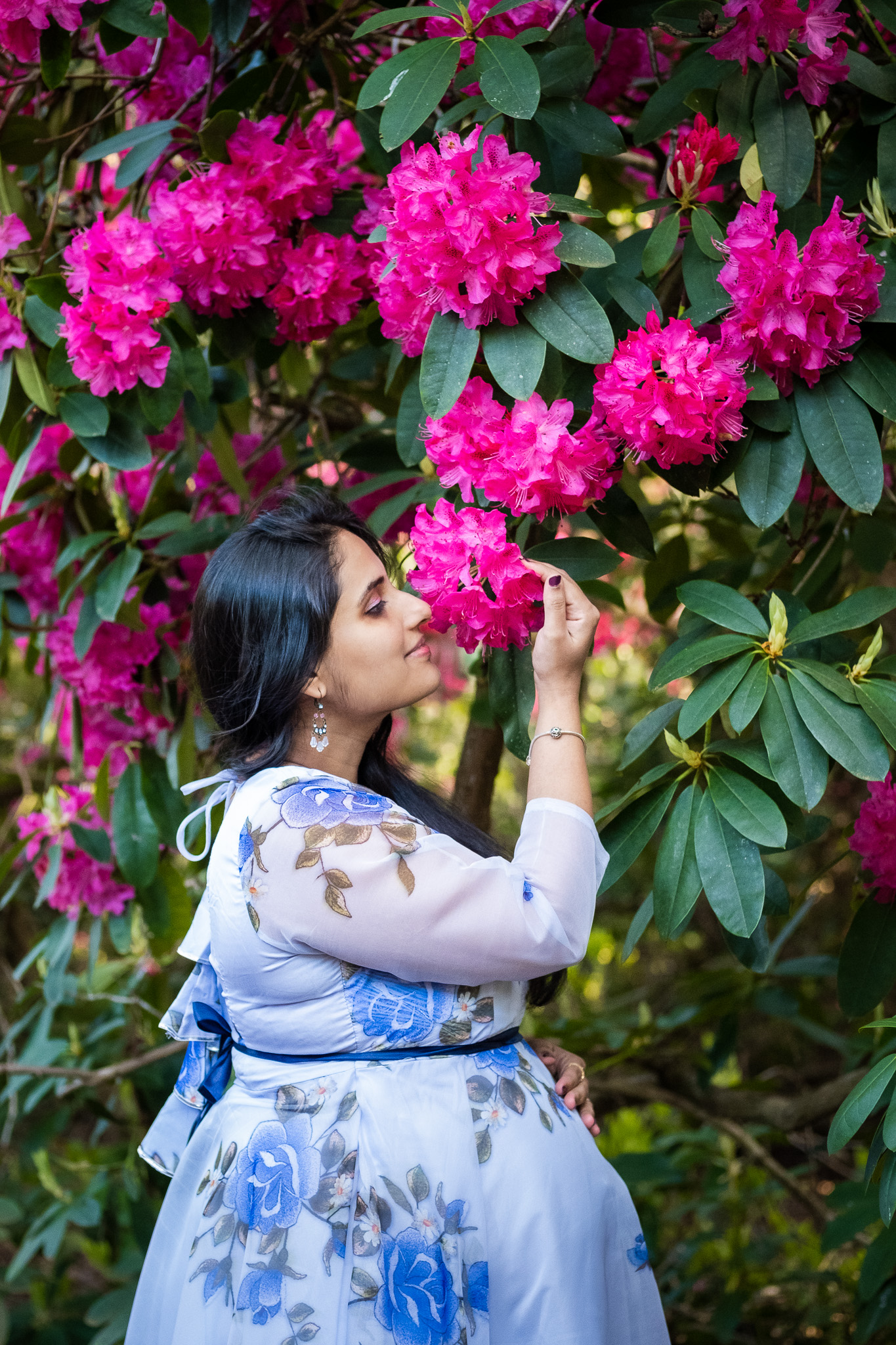 Pregnant woman enjoys the smell of spring flowers